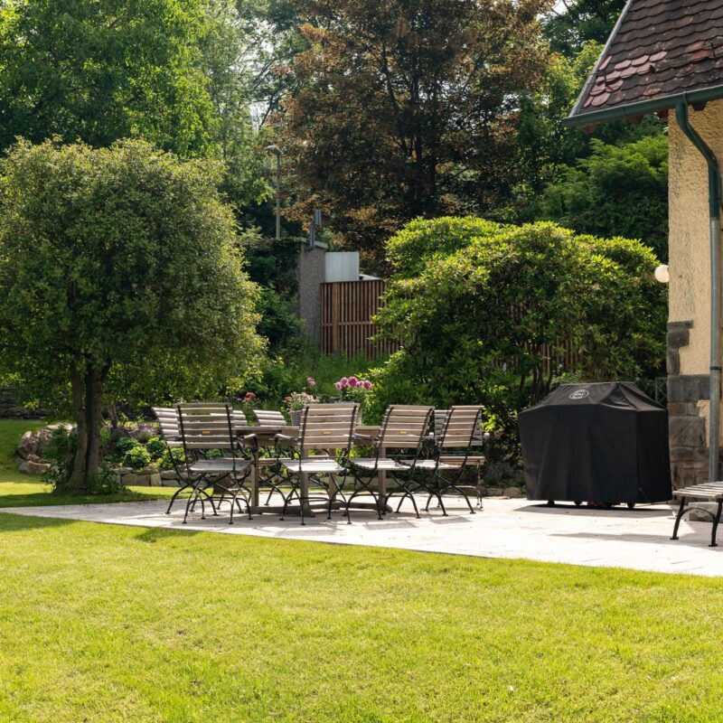 Rasenfläche mit Terrasse und Sitzplatz an einem Altbau