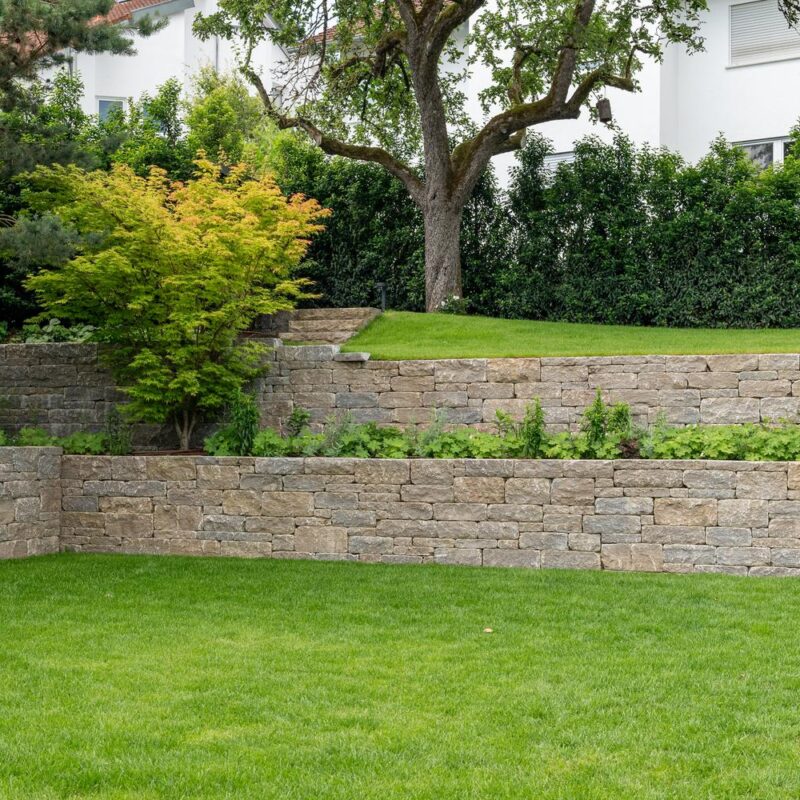 Terrassierung mit zwei Trockenmauern, Beeten und Rasenfläche